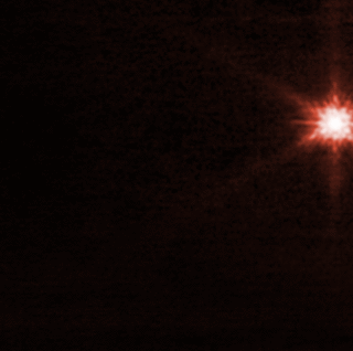 Animazione del sistema di asteroidi Didymos-Dimorphos dopo l'impatto DART. Questa vista di colore rosso da JWST mostra un centro luminoso e strisce più scure che si irradiano da esso. Deboli fili sembrano fluire verso l'esterno dal centro nel corso dell'animazione.